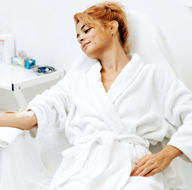 woman in white plush bathrobe while sitting in chair at the treatment procedure